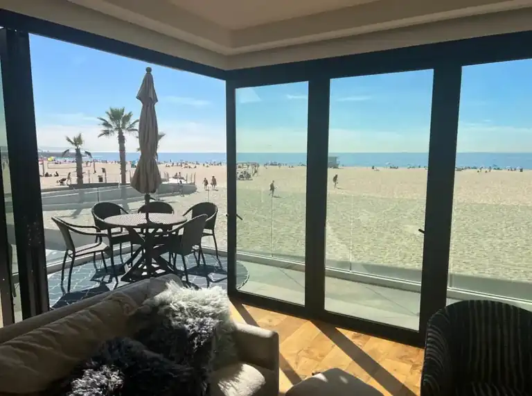 Hurricane impact sliding glass doors guide: black-framed glass doors opening onto an oceanfront balcony
